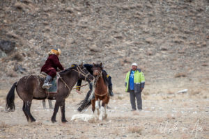 Two horseback Kazakh eagle hunters fighting over a sheep, Golden Eagle Festival, Olgii Mongolia