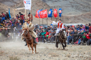 Young Kazakh man and woman horseback, Golden Eagle Festival, Olgii Mongolia