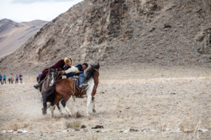 Two horseback Kazakh eagle hunters fighting over a sheep (Kokpar/Kuk- Bar), Golden Eagle Festival, Olgii Mongolia