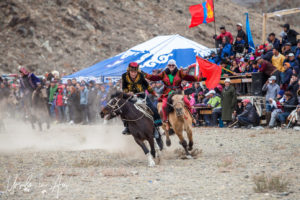 Young Kazakh man and woman horseback, Golden Eagle Festival, Olgii Mongolia