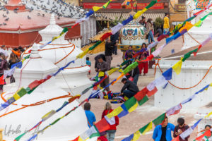 Men tying flags together on a landing, Boudhanath Stupa, Kathmandu Nepal