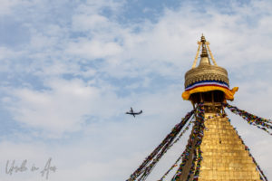 Airplane in the skies behind the spire of Boudhanath, Kathmandu Nepal
