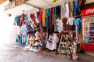 Man on his phone, gift shop outside Deir Al Bahri, Luxor Egypt