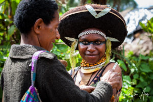 Young Enga woman being helped into traditional costume, Western Highlands, Papua New Guinea