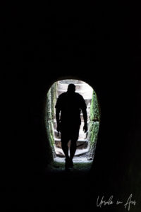 Silhouette of a man walking our of a dark tunnel, Hocking Hills State Park, Ohio