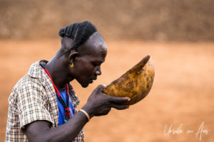 Hamar man drinking from a gourd, Omo Valley Ethiopia