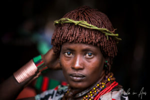 Young Hamar woman with leaves in her hair, Omo Valley Ethiopia