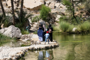Islamic family walking around the water, Wadi Bani Khalid, Oman