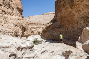 People on the rocky cliffs, Wadi Bani Khalid, Oman