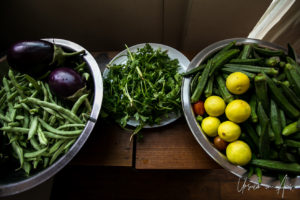 Bowls of beans, eggplant, coriander, okra, tomatoes and lemons.