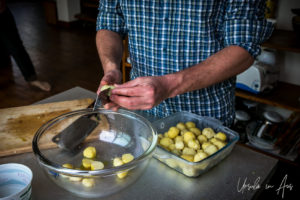 Man's hands cutting boiled potatoes.