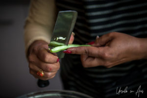 Woman's hands slicing green beans.