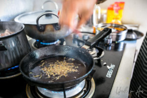 Ginger and garlic toasting in a iron fry pan.