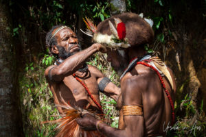 Two Huli Wigman fixing a headdress, Paiya Village, Papua New Guinea.