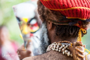 Portrait: Western Highland man applying face paint in a hand mirror, Paiya Village, Papua New Guinea.
