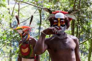 Portrait: Western Highland man in face paint smoking, Paiya Village, Papua New Guinea.