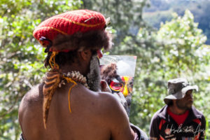 Western Highland man applying face paint in a hand mirror, Paiya Village, Papua New Guinea.
