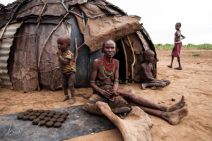 Seated Daasanach woman outside a hut, Omo Valley Ethiopia