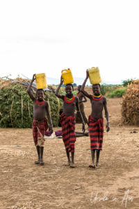 Three Daasanach Teen girls carrying water, Omo Valley Ethiopia