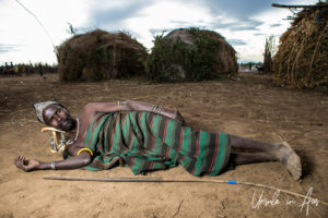 Daasanach Man Reclining on the ground, Omo Valley Ethiopia