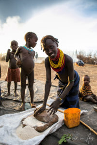 Daasanach woman stone-grinding grain, Omo Valley Ethiopia