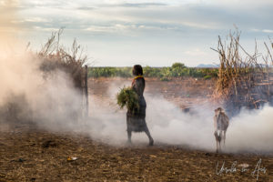 Woman in fire smoke, Daasanach Village, Omo Valley Ethiopia