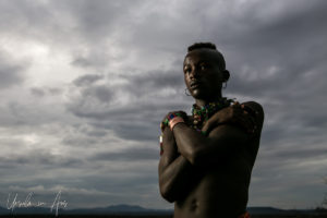 Portrait: Young Hamar man against a dark sky, Omo Valley Ethiopia
