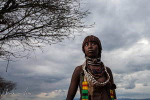 Portrait: Young Hamar woman against a dark sky, Omo Valley Ethiopia