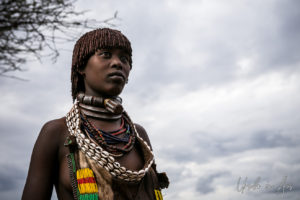 Portrait: Young Hamar woman against a dark sky, Omo Valley Ethiopia