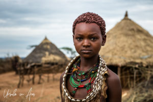 Portrait: A Hamar girl woven huts, Omo Valley Ethiopia
