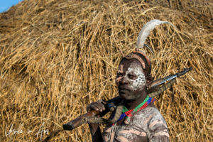 Portrait: Kara man with an AK47 in a Skull Cap and face paint, Dus Village, SNNPR Ethiopia