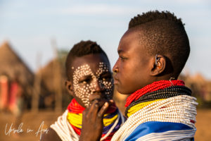 Portrait: young Kara women face painting each other, Omo Valley Ethiopia