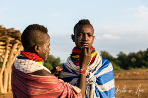 Portrait: young Kara women face painting each other, Omo Valley Ethiopia