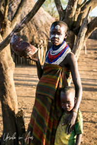 Dus woman with a gourd and a toddler, Omo Valley Ethiopia
