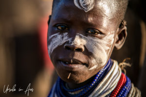 Portrait: Kara woman in face paint with a small stick under her lip, Omo Valley Ethiopia