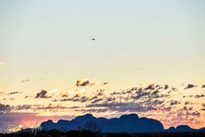 A tiny-looking helicopter in the skies over Kata Tjuta, Yulara, NT Australia