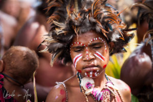 Young Papuan woman In brown feathered headdresses, Mount Hagen PNG.