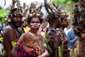 Papuan woman and infant In brown feathered headdresses, Mount Hagen PNG.