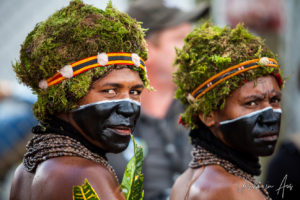 Portrait: Papuan women in black face paint and green moss headdresses, Mount Hagen PNG.