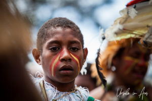 Portrait: Papuan child in a crowd of sing sing dancers, Mt Hagen PNG