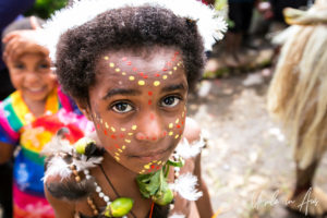 Portrait: Papuan child in a crowd of sing sing dancers, Mt Hagen PNG