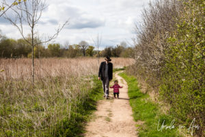 Man and a toddler walking a path along the Wye, Herefordshire, UK.