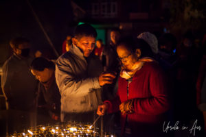 Nepali man and woman lighting lamps, Boudhanath, Kathmandu