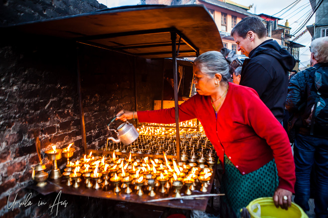 Nepali woman filling oil candles, Boudhanath, Kathmandu Nepal