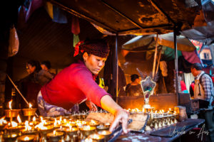 Nepali woman tending oil candles, Boudhanath, Kathmandu Nepal