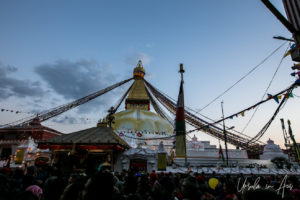 Crowd around the base of Boudhanath in evening light, Kathmandu Nepal.