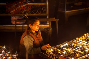 Nepali woman lighting lamps, Boudhanath, Kathmandu