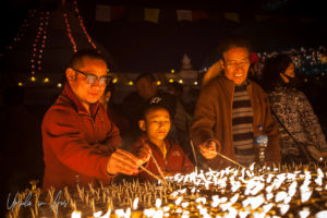 A monk and a novice lighting lamps, Boudhanath, Kathmandu