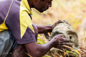 Close up: Man crafting an Asaro Mud Mask, Mt Hagen Papua New Guinea