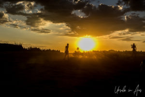 Silhouette of men and goats in a dusty sundown, Omo River, Ethiopia